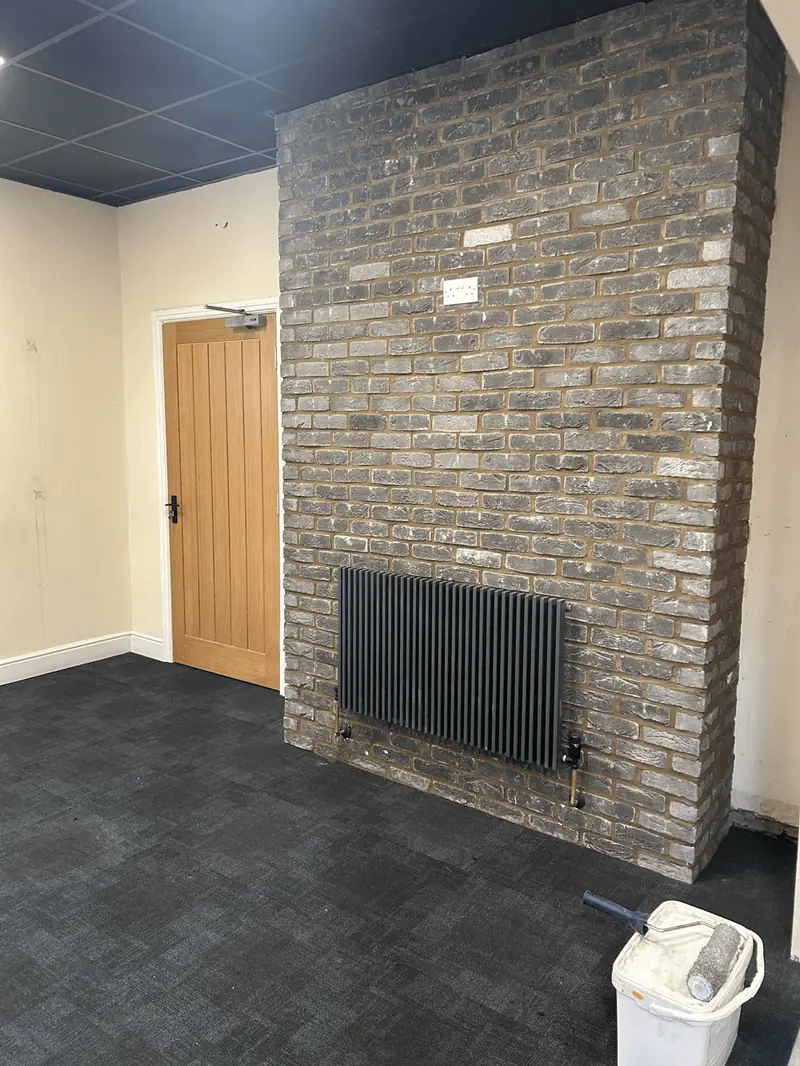 Finished interior floor beside a brick feature wall