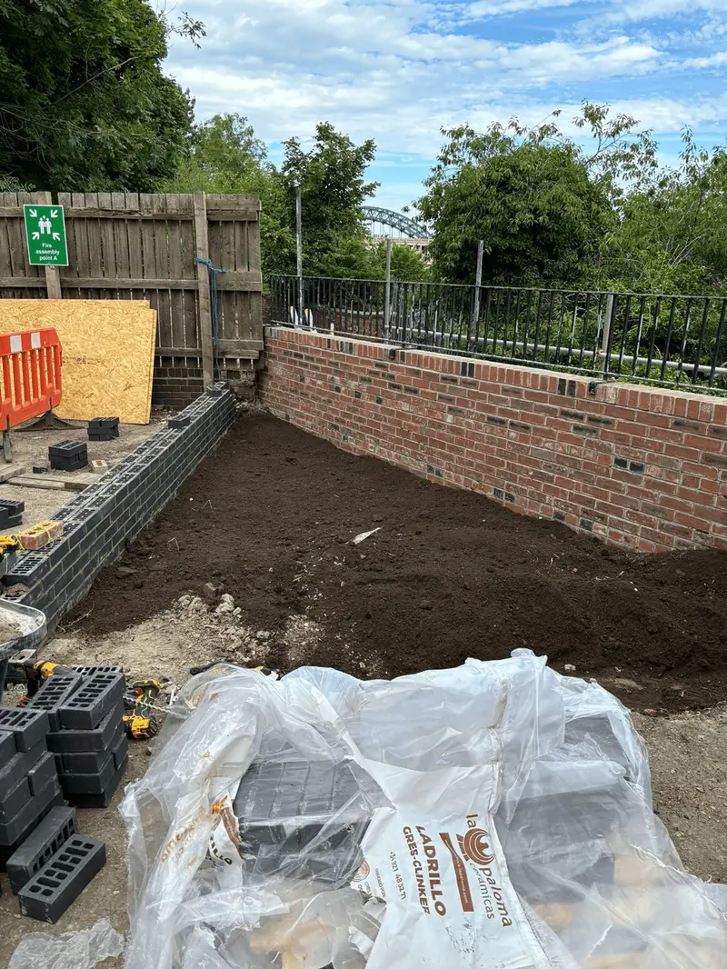 Excavation behind a new brick retaining wall