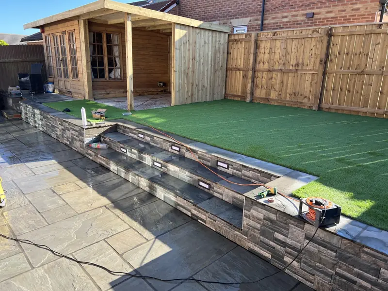Raised lawn with brick slip retaining wall